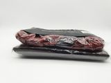 two bags of red meat sitting on top of each other