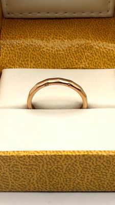 a gold ring sitting in a box on a white surface