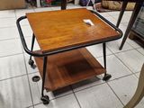 une table avec un plateau en bois montée sur roulettes dans une pièce