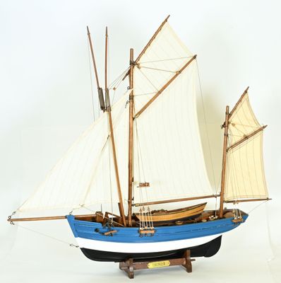 a model of a boat with sails on a stand