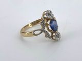 a close up of a gold ring with a blue stone and diamonds