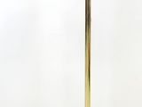 a gold table lamp with a white wall behind it