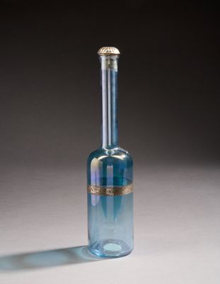 blue glass bottle with a gold rim on a white surface