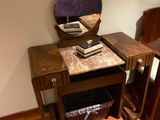 a small table with a mirror on it and a chair next to it