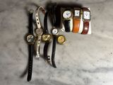 Trois montres et une montre-bracelet sont posées sur une surface en marbre
