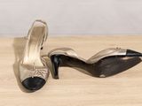 pair of black and gold high heel shoes on a wooden table