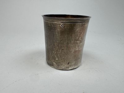 a small metal cup that is sitting on a table
