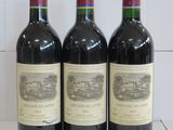 Trois bouteilles de vin rouge sont alignées sur un comptoir
