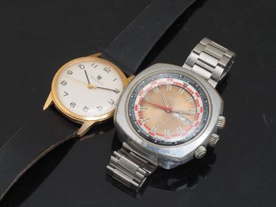 deux montres posées l'une à côté de l'autre sur une surface noire
