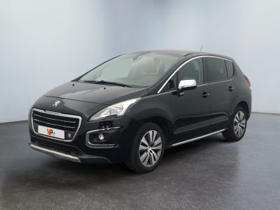 La voiture noire est garée dans une pièce aux murs blancs.