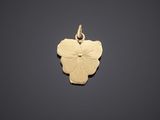 a small gold flower charm on a black background