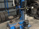 a machine that is sitting in a garage next to tires
