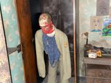 a dummy in the doorway of a room with peeling paint on the walls