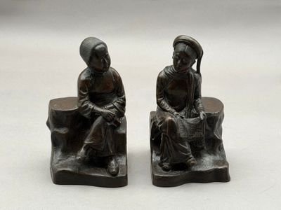 paire de figurines en bronze représentant une femme et un homme assis sur un banc