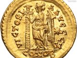 a gold coin with an image of a man holding a sword