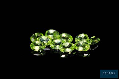 a close up of a group of green gems on a black background