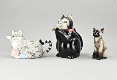 three figurines of cats sitting next to each other