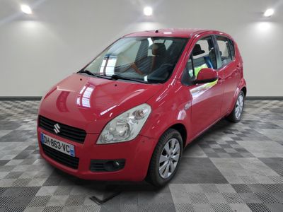La petite voiture rouge est garée dans le garage, sur le sol à carreaux.