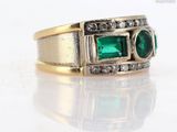 an image of a close up of a ring with emeralds and diamonds