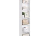 the tall white bookcase is filled with books and baskets