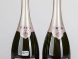 deux bouteilles de champagne posées l'une à côté de l'autre sur une table