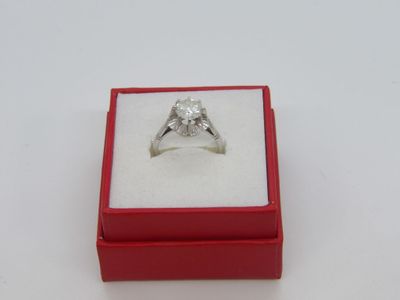 une photo d'une bague en diamant dans un écrin rouge posé sur une surface blanche