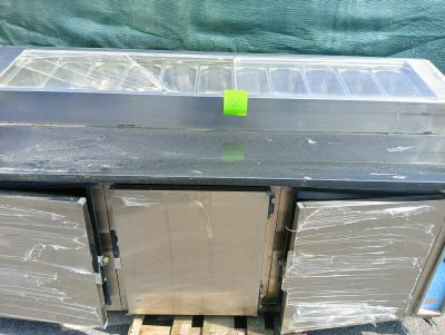 un plan de travail en métal sur lequel est posé un récipient en plastique