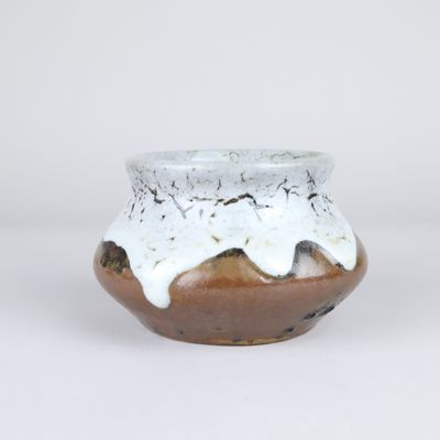 un petit vase marron et blanc recouvert d'un émail blanc