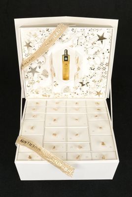 une boîte ouverte contenant un flacon de parfum, sur fond noir