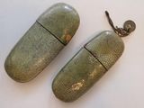 pair of green and silver pill shaped earrings on a white surface