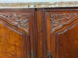 a wooden cabinet that has a marble top on top of it
