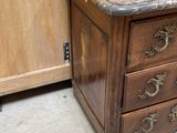 a wooden cabinet with a marble top and a marble top drawer