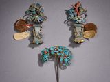 trois broches de couleur argentée et turquoise sur un fond gris