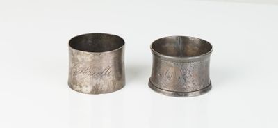 une paire de porte-serviettes anciens en pewter posés sur un support blanc