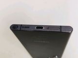 the back of a black cell phone sitting on top of a white table