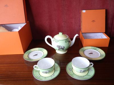 plusieurs tasses et soucoupes sont posées sur une table avec une boîte à l'arrière-plan