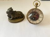 une petite horloge et une petite figurine de chien posées sur une table