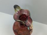 a glass vase with a flower on it on a table