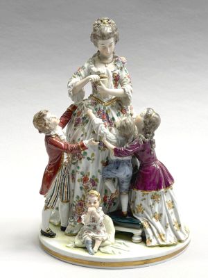 une figurine représentant une femme avec des enfants et un chien