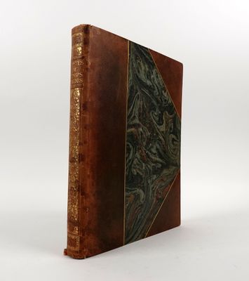 un vieux livre à la couverture brune posé sur une surface blanche