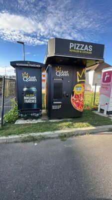 a small pizza kiosk on the side of the road