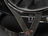 an old black helmet with a metal buckle on a black background