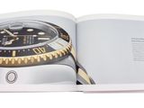 an open book with a picture of a watch on it
