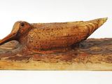 carved wooden duck figurine on a wooden base with a white background