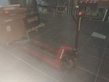 a red fork lifter sitting on the floor in a room
