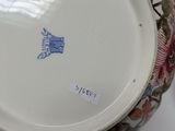 a close up of a plate and a vase on a table