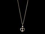 un collier en or avec un pendentif en forme de cœur sur une chaîne