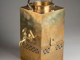 a brass tea kettle that is sitting on a table