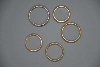 six anneaux dorés disposés en cercle sur une surface grise