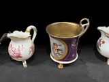Quatre vases en porcelaine de styles différents sont alignés sur une surface noire